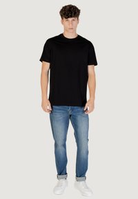 Must musta särk, lühikeste varrukatega, ümmarguse kaelusega, koos helesiniste teksade ja valgete tossudega, esitletud neutraalsel taustal.