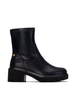 Bota de cuero negra hasta la mitad de la pantorrilla con tacón grueso, punta redonda, costura lateral y un pequeño emblema dorado cerca del talón sobre un fondo blanco.