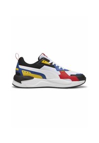 Baskets Puma avec un design blanc, rouge, bleu et noir, une tige texturée, des accents jaunes contrastants et une semelle épaisse pour le soutien.