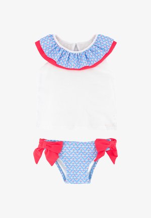 Top blanco sin mangas con cuello azul con volantes, decorado con formas blancas y rojas, combinado con braguitas de bikini azules con grandes lazos rojos.
