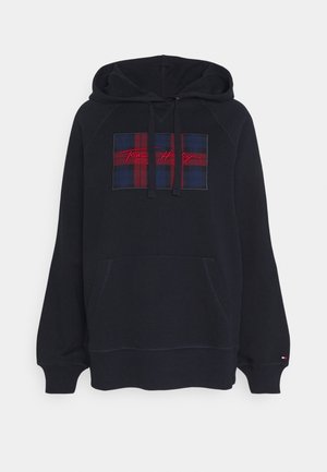Sudadera con capucha negra con un parche de cuadros azul y rojo. Cuenta con un bolsillo frontal, capucha con cordón y un logo de la marca bordado en rojo.