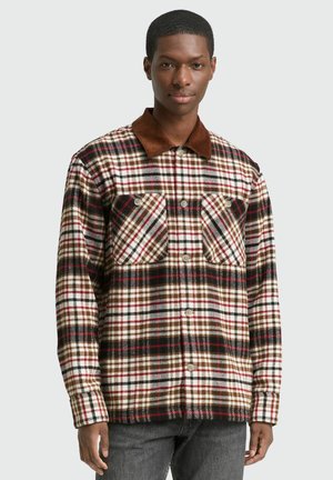 Geruite flanellen shirt in crème, rood en bruin met een corduroy kraag, voorzien van twee voorzakken en knoopsluiting. Getextureerde stof.