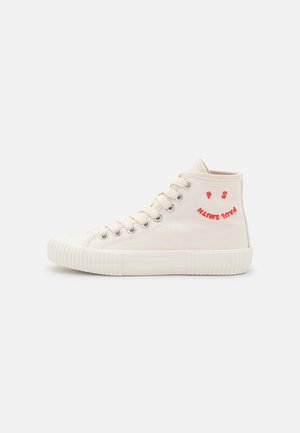 Zapatilla de lona beige de caña alta con suela y puntera de goma blanca, ojales metálicos, cordones y texto rojo "PAUL SMITH" formando una cara sonriente.
