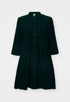 Vestido de veludo cotelê verde escuro com fecho de botões na frente, colarinho mandarim, mangas de três quartos e cintura franzida para um toque adicional.
