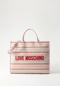 Tote torba z svetlo roza ročaji, s kanvasom črtastega vzorca v rdeči in kremni barvi, na eni strani pa je v drznem rdečem tisku napisano "LOVE MOSCHINO".