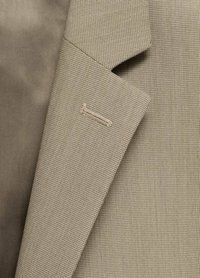Beige textil med struktur och rutmönster, med en spetsig krage och en liten sydd detalj på kanten.