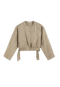 Chaqueta corta beige con mangas largas, cintura fruncida y cierres de lazo. Presenta un patrón texturizado con hilos metálicos. Tejido suave.