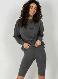 Szary, prążkowany sweatshirt z napisem „ANGEL” oraz dopasowane prążkowane szorty rowerowe. Casualowy krój i faktura z długimi rękawami oraz wygodnym paskiem w talii.