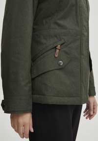 Green polyester jacket with a textured finish, featuring a side pocket, button detail, and adjustable cuffs. Simple, functional design.