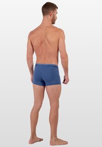 Modré bavlněné boxerkové šortky s páskem se znakem. Design je klasický, s přiléhavým střihem a délkou do poloviny stehen.