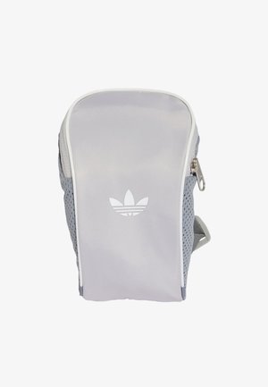 Mała jasnoszara saszetka Adidas z białym logo z przodu, siateczkowymi panelami bocznymi i zamkiem błyskawicznym po prawej stronie.