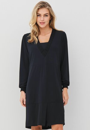 Svart klänning med långa, något puffade ärmar, V-ringning och texturerade detaljer. Slätt tyg med en avslappnad passform, medellång design.