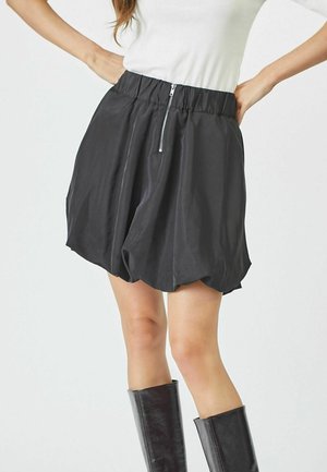 Black bubble skirt in lightweight fabric, featuring a gathered elastic waistband and a front zipper detail. Smooth texture with rounded hem.