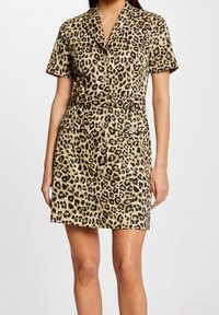 Sukienka w panterkę z krótkimi rękawami, z przodu zapinana na guziki, z paskiem w talii, dwoma przednimi kieszeniami oraz lekko rozkloszowanym dołem w odcieniach beżu i czerni.