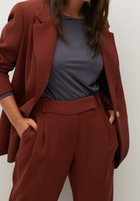 Maroons blazer med gyldne knapper, parret med slim-fit plisserede bukser og en mørkegrå skjorte. Glat stof med skræddersyet design.