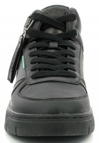 Sneaker nera in pelle con punta rotonda, lacci neri e tomaia strutturata; presenta un accento verde di lato e un piccolo etichetta.