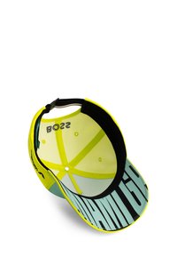 Neon żółta czapka baseballowa z czarnym i miętowym logo na daszku. Wnętrze ma czarne wykończenie i regulowany pasek.