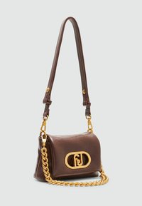 Bruine leren handtas met een gouden kettingriem, ovale logo-detail op de voorkant en een gladde textuur. compact rechthoekige vorm.