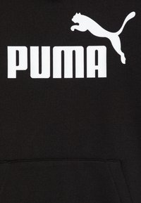 Svart hettegenser med hvit "PUMA"-logo og design av en hoppende katt. Har en myk tekstur og en lomme foran.