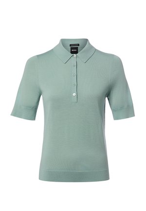 Polo vert clair à manches courtes avec col et quatre boutons sur le devant, en tissu fin tricoté.