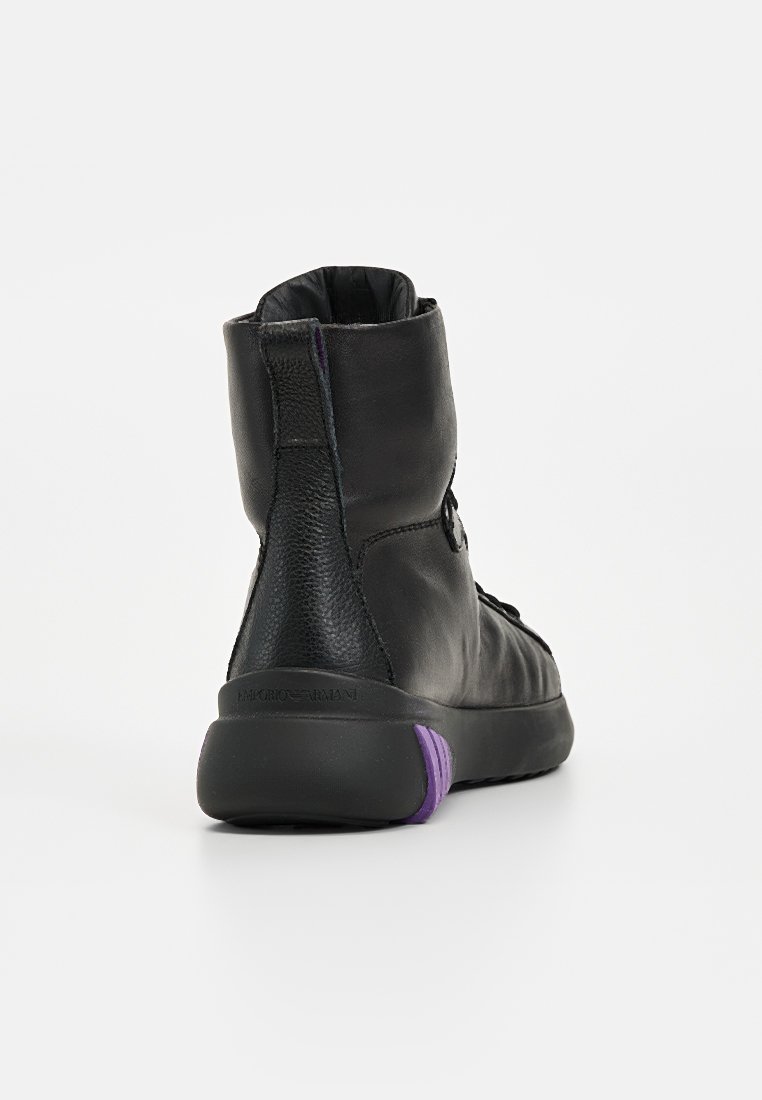 Schwarze Leder-Ankle-Boots mit strukturierten Akzenten, einem gepolsterten Kragen und einem lila Detail an der Ferse. Entworfen für Komfort und Unterstützung.