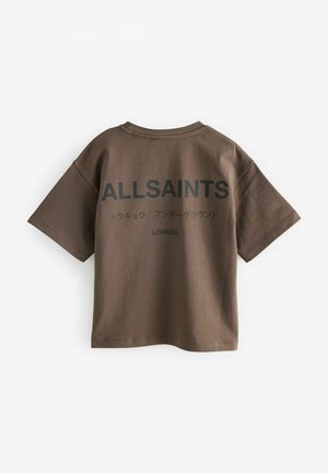 Brun kortärmad t-shirt med rund halsringning, med fet svart text på baksidan: "ALLSAINTS LONDON" och ytterligare text på japanska.