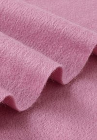 Feltro rosa, texture morbida, stratificato con bordi ondulati, che mostra una superficie liscia e sottili variazioni di profondità.