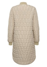 Beige quiltattu pitkä takki pyöreällä helmallä, resoreilla hihoissa ja pyöreällä kauluksella; siinä on timantinmuotoinen ommelkuviointi ja sileä pinta.