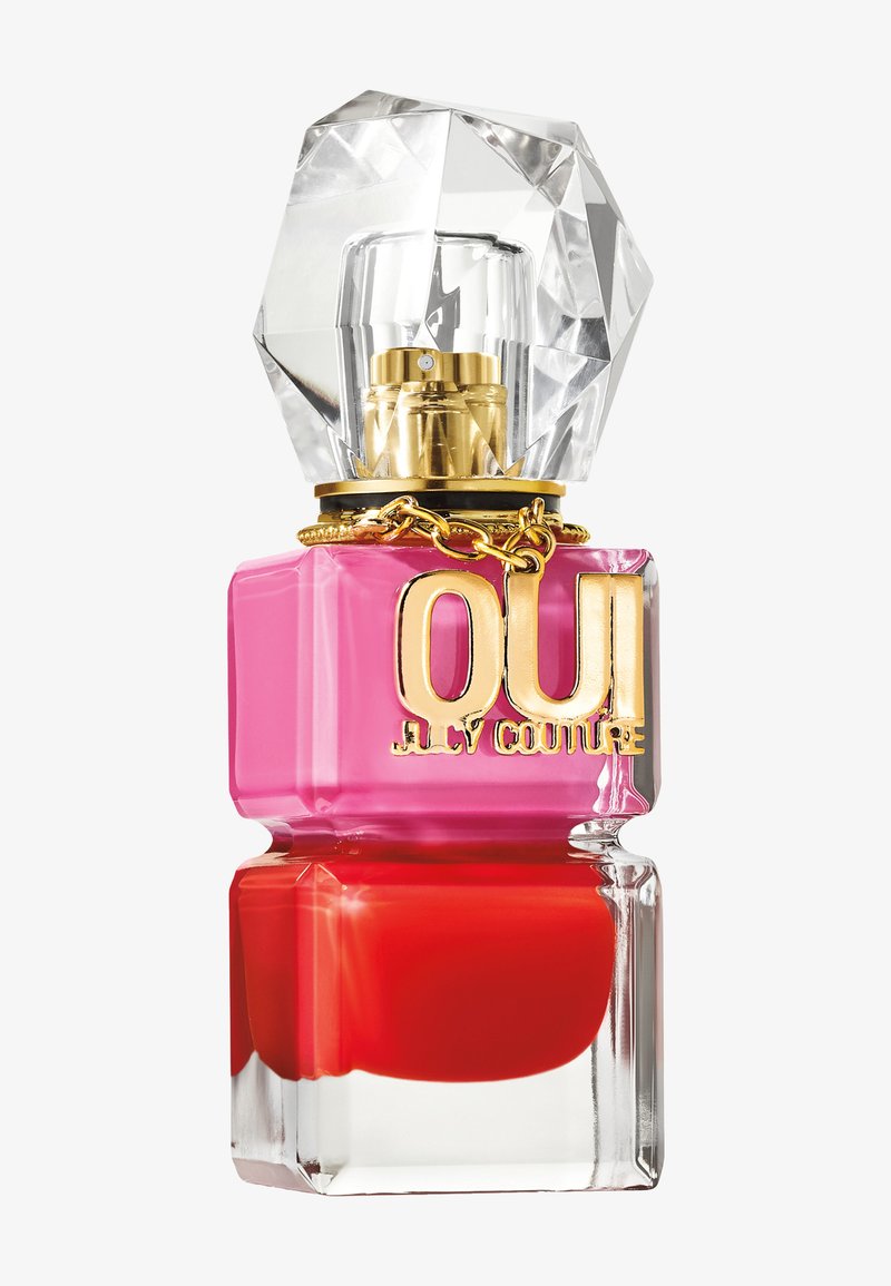 Flacon de parfum carré avec des parties rouges et roses, un grand bouchon façon pierre précieuse et une étiquette dorée indiquant OUI Juicy Couture sur une chaîne dorée.