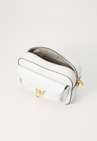 Borsa a tracolla in pelle bianca con esterno testurizzato, hardware dorato, chiusura con zip e tasca frontale con patta. Fodera in tessuto beige.