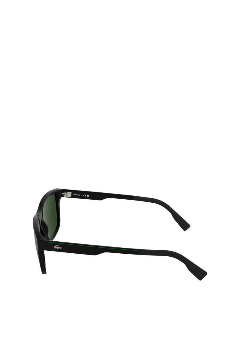 Lunettes de soleil noires avec des verres teintés en vert, dotées d'une monture rectangulaire et de branches épaisses. Logo Lacoste sur le côté et accents verts sur la monture.