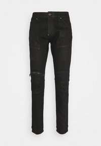 Černé slim-fit džíny se zipem na kotníku, nášivkami a zničenými detaily. Vyrobeny z denimu s hladkým, mírně texturovaným povrchem.