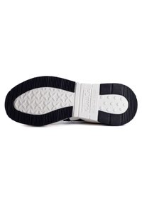 Black rubber sole with textured surface; features white cushioning midsole and branded heel. Design includes a star pattern and circular grips.