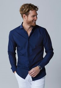Marineblauwe knoopsluiting shirt met een verbreide kraag, lange mouwen en een gladde textuur. Bevat zwarte knopen en een slim fit ontwerp.