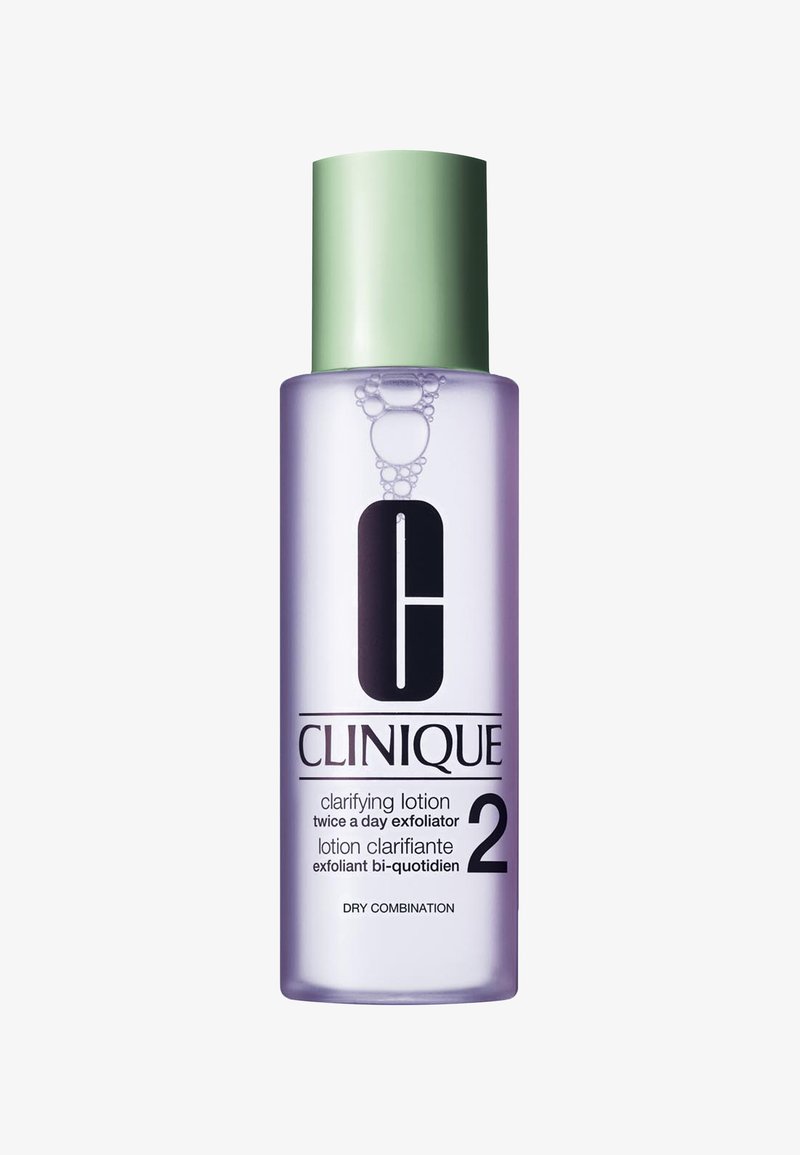 Clinique Clarifying Lotion 2 in een heldere fles met een groene dop. Etiket met zwarte tekst en een grafisch logo, met een paarse vloeistof erin.