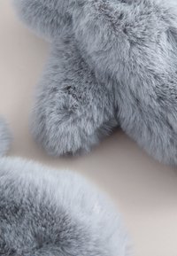 Gray faux fur material, soft texture, and fluffy form. Rounded shapes create a plush appearance with subtle color variations.