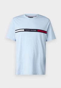 Camiseta de algodón azul claro con cuello redondo, mangas cortas y un diseño de rayas horizontales con detalles en negro, blanco y rojo.
