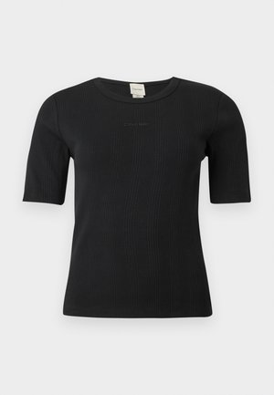 Czarny prążkowany top Calvin Klein z krótkim rękawem, okrągłym dekoltem i subtelnym logo wyszytym na piersi na jednolitym tle.