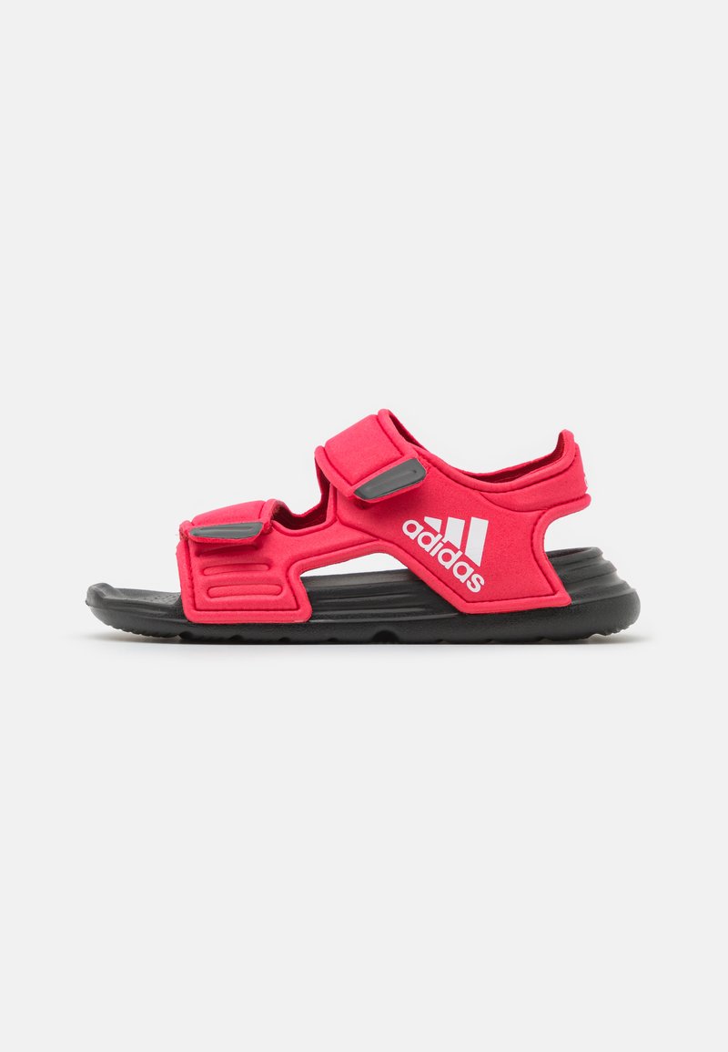 Sandalias deportivas rojas con correas ajustables, suela negra acolchada y marca blanca. Fabricadas con material sintético, presentan un diseño deportivo.