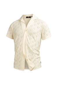 Camicetta a maniche corte color crema con un motivo testurizzato caratterizzato da piccole aperture. Colletto sartoriale, chiusura con bottoni e design slim fit.