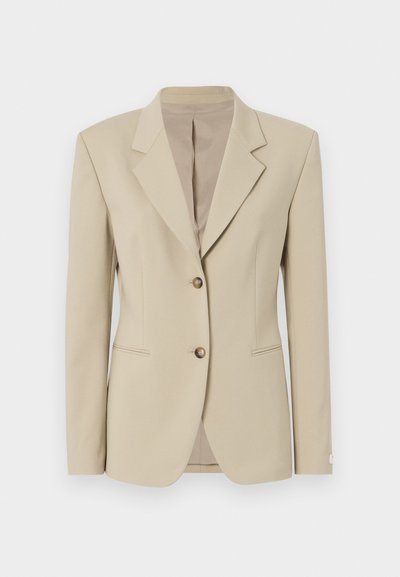 Beige blazer with a structured design, single-breasted front, sharp lapels, two buttons, and slight texture. Features tailored waist and pockets.