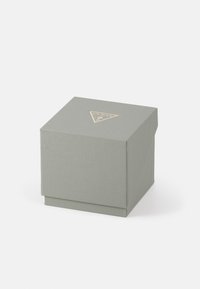 Quadratische, strukturierte graue Geschenkbox mit einem gefalteten Deckel und einem goldenen Dreieckslogo. verfügt über eine glatte Oberfläche und ein minimalistisches Design.