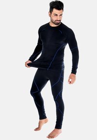 Schwarzes, sportliches Langarmshirt und Leggings mit blauen Akzenten und geometrischen Mustern, hergestellt aus einem dehnbaren, feuchtigkeitsableitenden Material.