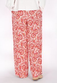 Široké kalhoty z lehkého materiálu s červeným a růžovým paisley vzorem. Design zahrnuje květinové akcenty a boční kapsy.