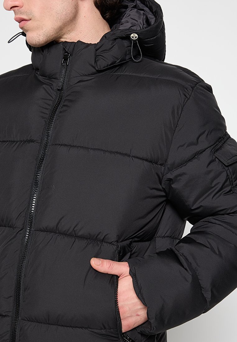 Giacca a vento nera con colletto alto, cappuccio e chiusura frontale con zip. Presenta un design trapuntato, polsini elasticizzati e tasche laterali.