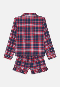 Punane, tumesinine ja valge ruuduline pikakä sleeves pidžaama särk koos sobivate volangidega lühikeste pükstega, esitatud valgel taustal.