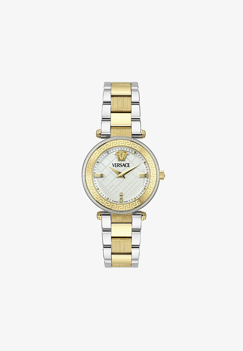 Kullatud ja hõbedast kahetooni metallkell tekstureeritud hõbedase suure näoga, Kreeka võtme mustriga bezelil ja kullast lõvi aktsendiga.