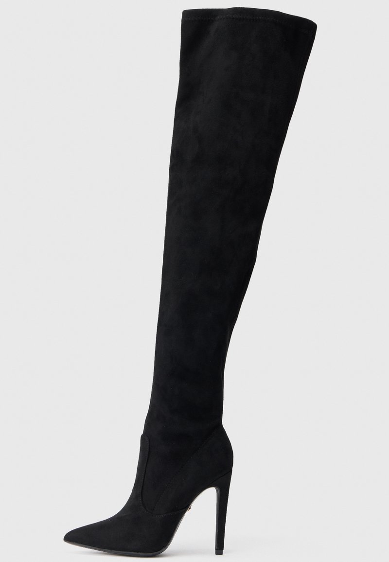 Melnas zamša zābaki līdz ceļiem ar izteiktu purngalu un augstu stiletto papēdi. Gluda teksta un pieguloša dizaina dēļ veido elegantu siluetu.