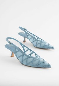 Blå syntetiske slingback hæle med spidse tæer, åbne sider og krydsmønster. Har en lille hæl og justerbar ankelrem.