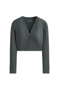 Sötétzöld, rövidített hosszú ujjú póló. Bordázott anyagból készült, V-nyakkivágással és öt gombos gallérral. Sima textúra, testhezálló kialakítás.